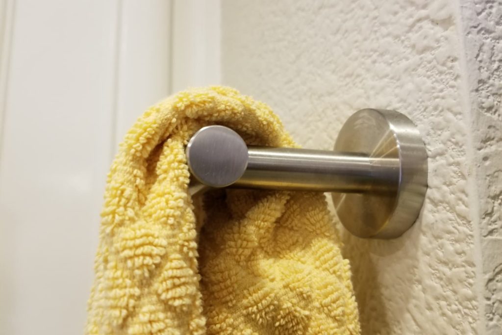 silver metal towel rack with yellow towel