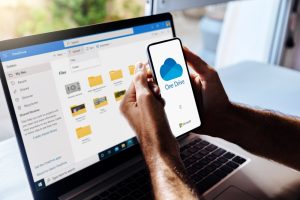 Person reviewing files in cloud storage on a laptop and smartphone