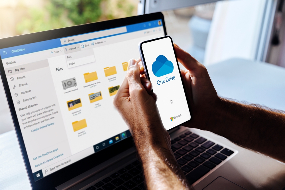 Person reviewing files in cloud storage on a laptop and smartphone